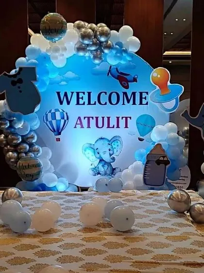 A close-up of a personalized "Welcome Atulit" backdrop. This elephant and hot air balloon themed setup is perfect for a baby boy's welcome party or Chhathi ceremony, featuring custom cutouts and a soft blue color scheme.