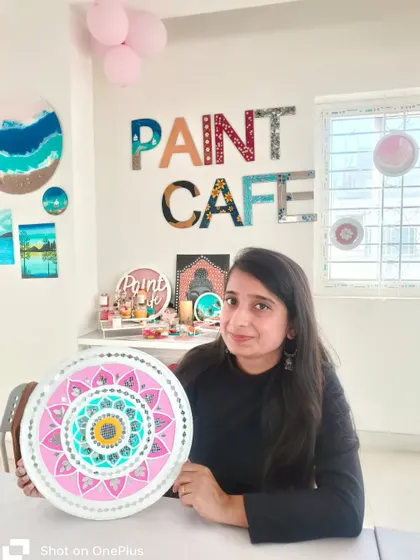A happy participant holding her gorgeous pink and turquoise Lippan art piece, created right here in the studio.