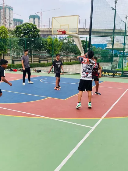 A senior player takes a three-point shot during practice.