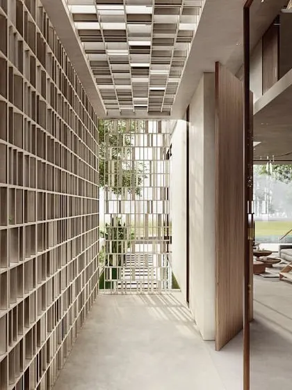 A screened, semi-open walkway at a Pavilion home creates a breathable threshold between inside and out. It filters light and air while guiding you towards the entrance foyer, which is centered around another courtyard.