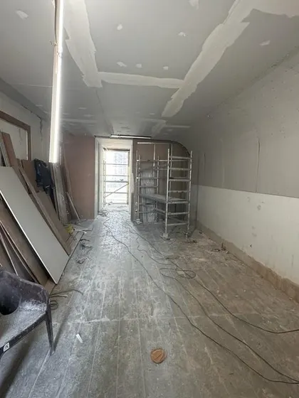 A raw corridor space during the early stages of construction at the Carlsberg site. This view shows the potential of the space before the installation of flooring, wall finishes, and lighting transforms it completely.