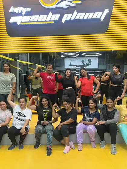 Getting strong together at Kitty's Muscle Planet. This picture captures the fun and camaraderie of our women's fitness group, flexing and celebrating our progress.