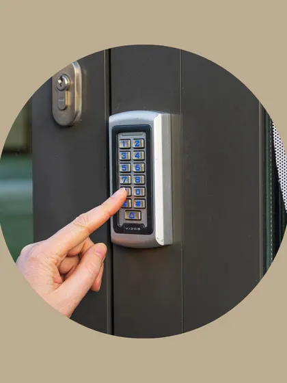 A person enters a code on a sleek, wall-mounted keypad. This showcases a keyless entry solution, providing secure and convenient access control for family members or trusted service providers without needing a physical key.