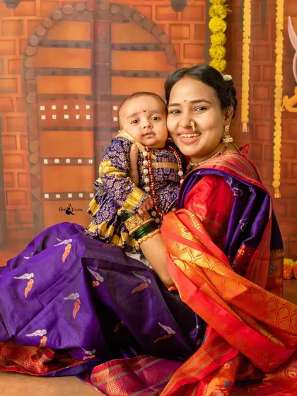 A proud mother holds her baby, who is dressed as the great warrior king Shivaji Maharaj. These portraits become cherished family heirlooms.