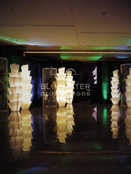 The entrance walkway lined with towers of pleated, illuminated fabric lamps, creating a grand and dramatic welcome.