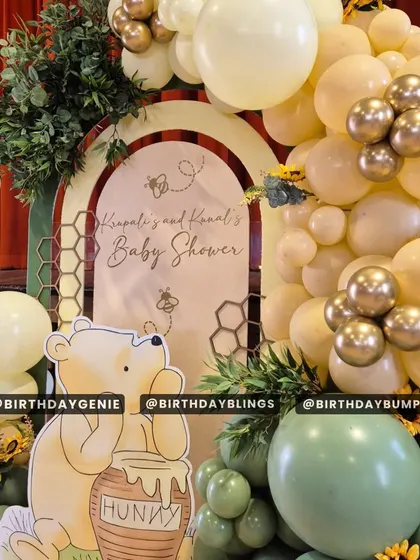 A close-up of a Winnie the Pooh baby shower theme, featuring a "Hunny" pot and honeycomb details. The soft yellow and green balloons create a warm and gentle atmosphere.