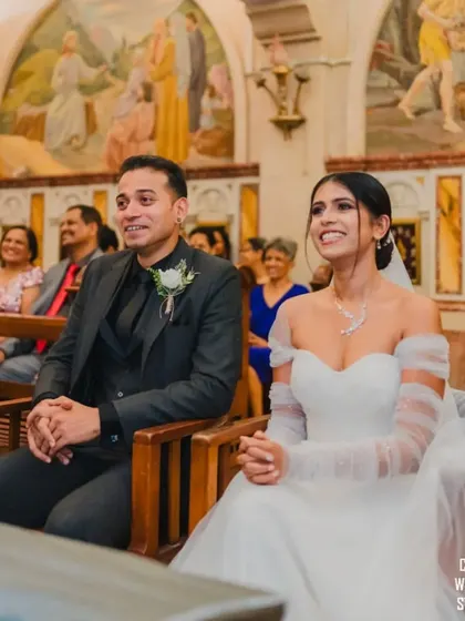 A candid shot of the couple sharing a happy, relaxed moment while seated during their wedding ceremony.