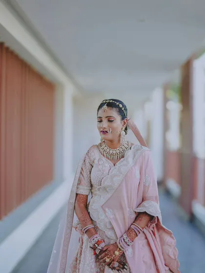 A serene portrait of the bride in a beautiful pastel pink lehenga, captured in a quiet moment.