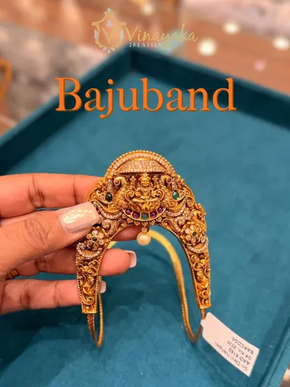 A close-up of a temple bajuband with Navratna stones surrounding the Lakshmi motif. The multi-color stones make it easy to pair with different silk sarees.