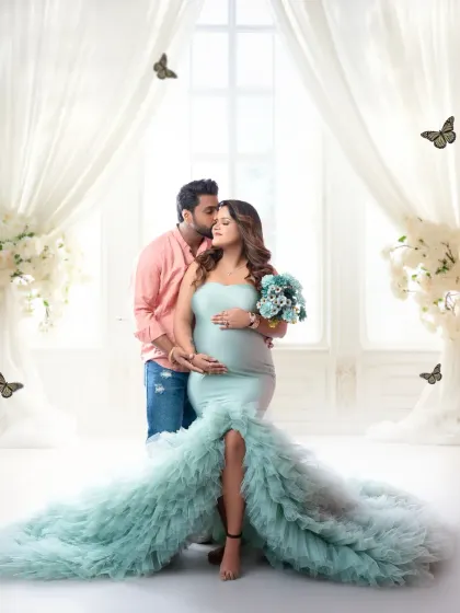 A glamorous maternity portrait for an expecting couple. The flowing sea-green gown and ethereal white drapes create a magical, romantic setting to celebrate the miracle of life.