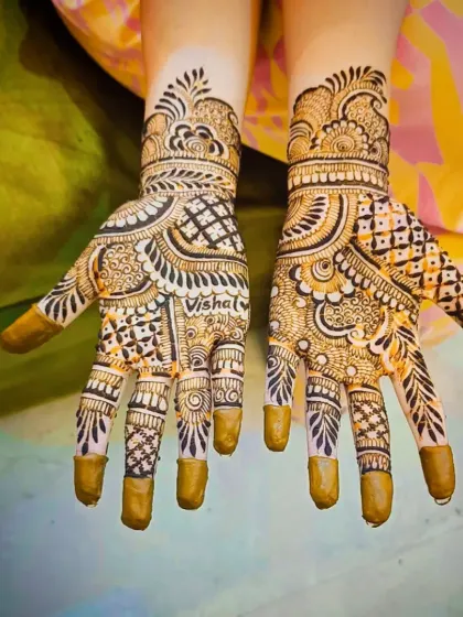 A view of the 'Vishal' design with henna-covered fingertips, a classic bridal choice.