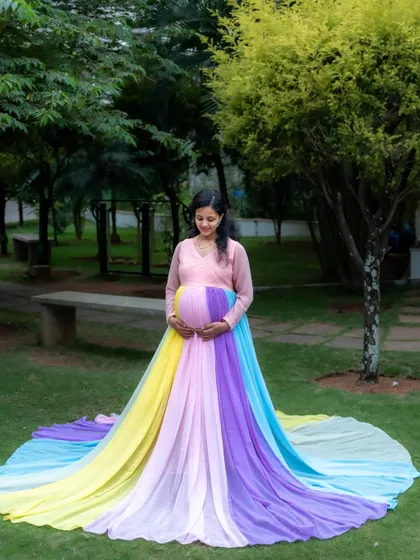 A full-length view of the beautiful rainbow gown, spread out on the grass in a lovely park setting. This shot showcases the dress in all its colorful glory.