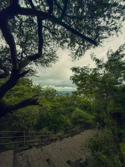 The stone steps leading down from the Pandavleni Caves, with a view of the city in the distance. The path itself tells a story of countless visitors over the centuries.