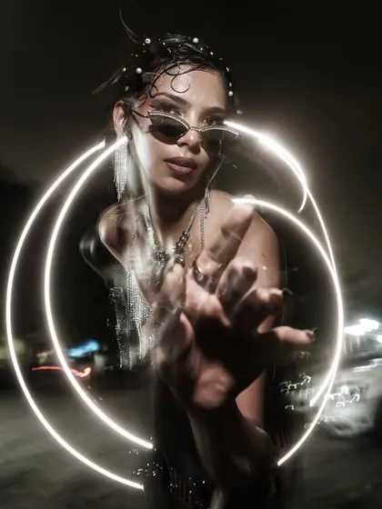Another creative light painting portrait. Here, the light circles the model's hand, drawing the viewer's eye and creating a sense of magic.