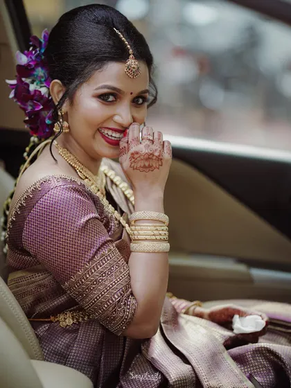 A candid shot of the bride smiling from inside the car, a moment of quiet excitement before the ceremony begins.