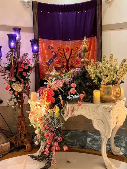 A detail shot from the Turkish-themed event, showing a beautiful floral arrangement on an ornate white table, with a traditional textile in the background.