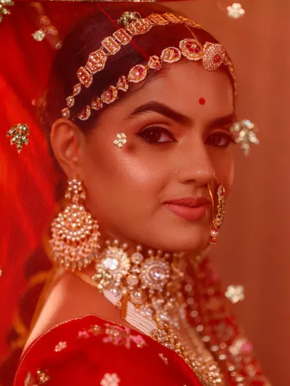 An artistic shot through the sheer red veil, focusing on the model's expressive eyes and the traditional unibrow makeup specific to the Padmavati character. We nail every detail for authentic recreation.