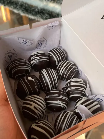 A box of our Christmas rum balls, a classic holiday treat made with chocolate, cake crumbs, and a hint of rum.
