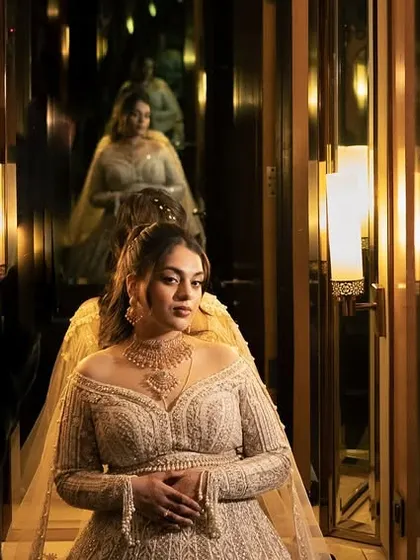 A creative portrait using reflections to create an infinity effect. The bride, in her magnificent reception gown, looks like a queen in a hall of mirrors.