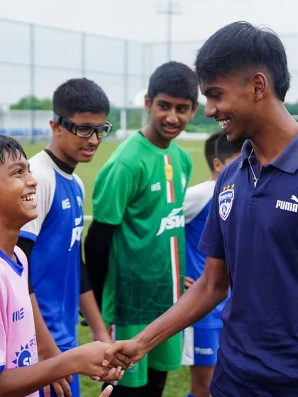 A BFC player shares a handshake and a smile with a young player from Pune. These moments create lasting memories.