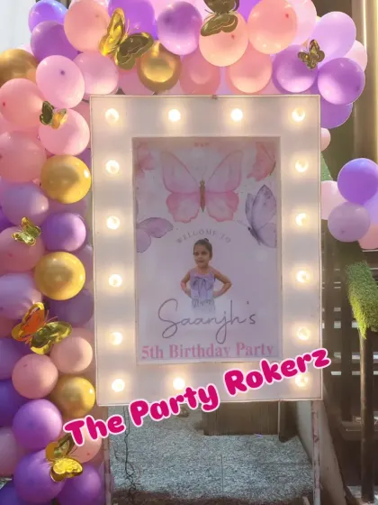 A personalized welcome sign is a great way to greet guests. For this party, I framed the sign with lights and a matching purple and pink balloon arrangement.