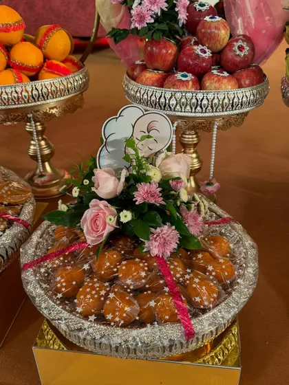 A platter of sweets decorated for a baby shower. I used fresh pink roses and a cute baby chef cutout to create a unique and charming look for the occasion.