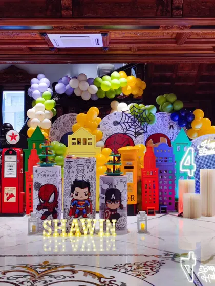 A full superhero cityscape for Shawin's 4th birthday. The backdrop features colorful buildings and comic book graphics, with light-up letters adding a personalized touch to the dynamic scene.