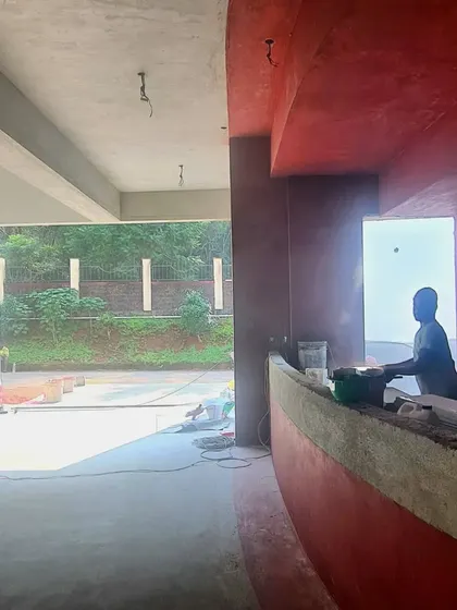 A silhouette of a worker against an opening at the TAPMI Centre site, a quiet moment amidst the activity of construction.