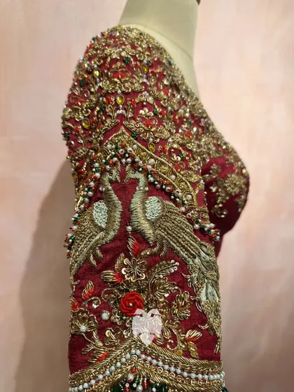 The sleeve detail of Madhavi's blouse, highlighting the temple artistry with peacocks embroidered in antique gold zardosi.