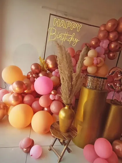 A cascade of rose gold and peach balloons creates a beautiful, abstract backdrop, showing that decor can be stylish without a specific theme.