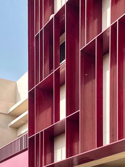 A work-in-progress shot of the facade at the SMBV school. These deep red fins aren't just for looks; they are a key part of our sun-shading solution, designed to block harsh sunlight and help keep the classrooms cool.