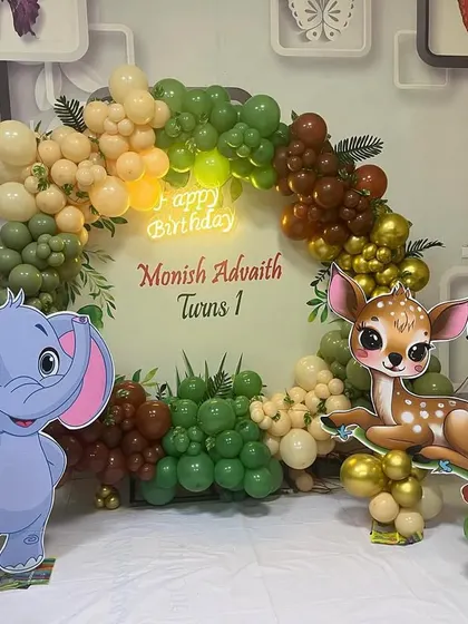 This jungle theme birthday decoration brings the wild indoors. It features a balloon arch in earthy tones, a personalized backdrop, and large cutouts of friendly cartoon animals like an elephant, deer, and toucan for the kids to enjoy.