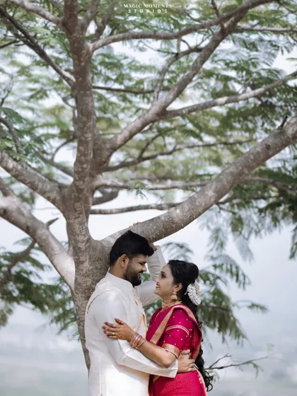 A romantic outdoor portrait of Chethan and Muduganga from their engagement shoot, framed by the branches of a large tree.