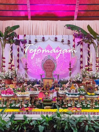 A baby shower setup with a unique backdrop featuring a lotus design and banana trees, creating a natural and auspicious setting.