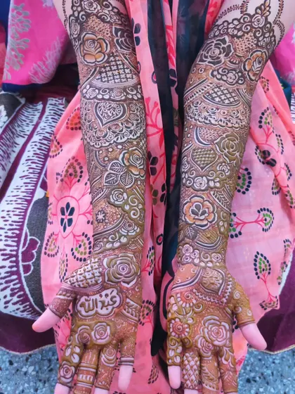 A full view of a bridal design featuring the groom's name, Abdullah, and a beautiful mix of floral and heart patterns.