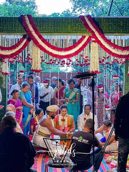 A behind-the-scenes look at a traditional wedding ceremony. The mandap is adorned with coconut leaf wraps, chrysanthemums, and tuberose, creating a serene and beautiful backdrop for the sacred union.