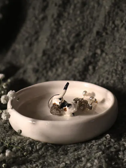 This calico cat ring holder is a beautiful and practical piece. The cat's tail is perfect for holding rings, and the dish can hold other small jewelry.