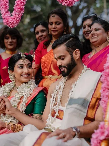 A quiet moment during the Oonjal (swing) ceremony. This shot captures the couple's gentle interaction, surrounded by family and beautiful floral decorations.