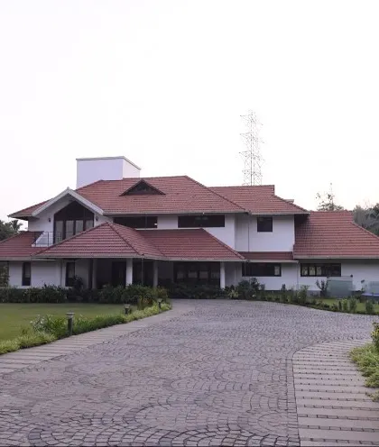 We also undertake large-scale projects like this estate house in Thrissur for Mr. Alex. The design balances a grand scale with traditional architectural forms, including sloping tiled roofs and deep verandas, creating a stately yet welcoming family home.