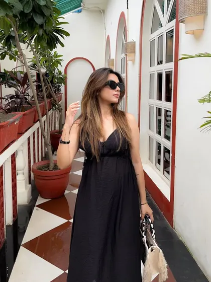 Walking down a beautiful tiled hallway in a breezy black summer dress.