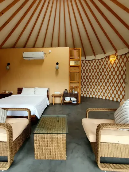 A full view of the spacious interior of our yurt-style cottage, combining a bedroom and living area in an open, airy layout.