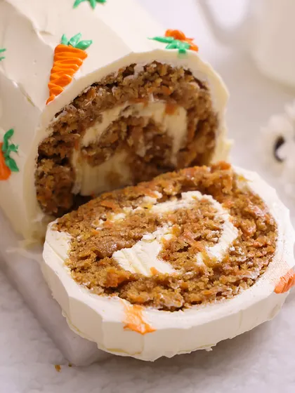 We put a twist on a classic with our Easter carrot roll cake. This delicious roll is filled with cream cheese frosting and decorated with tiny piped carrots and a chocolate nest, offering a unique and elegant alternative for your Easter dessert table.