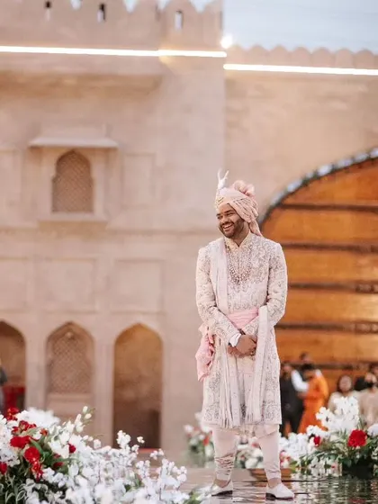 The groom's happy expression as he waits for his bride at the start of the aisle.