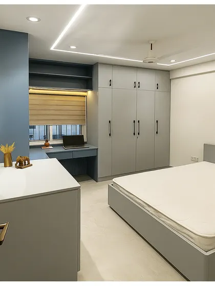 This bedroom design blends a cool grey-blue Duco finish with warm laminate textures. We created a functional layout with a full-wall wardrobe, a compact study desk by the window, and clean, linear cove lighting.
