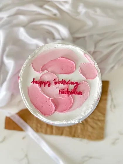 A simple flat cake with abstract pink strokes. This is a great example of a minimalist design that is still beautiful and eye-catching.