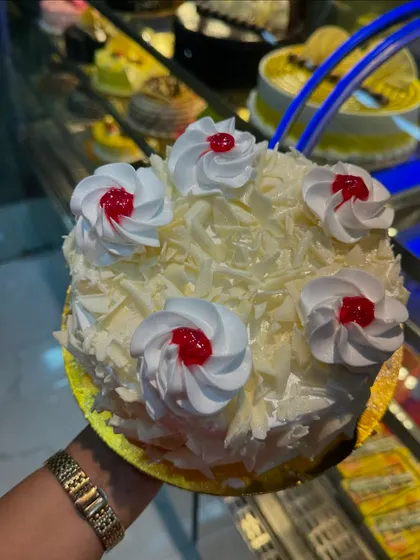 Our White Forest cake is a dream for anyone who loves white chocolate. It's covered in white chocolate shavings and topped with swirls of fresh cream and cherries.