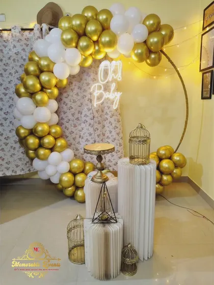 A simple and chic 'Oh Baby' decoration with a gold and white balloon ring, perfect for an intimate baby shower at home.