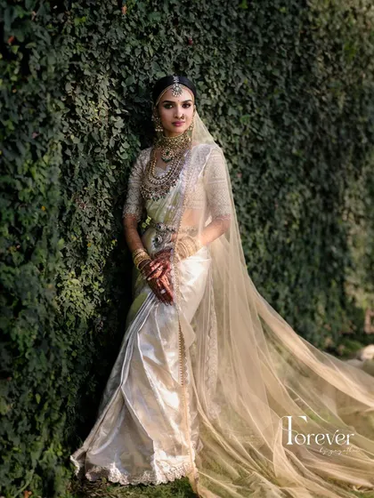 This bride looks like a queen. The flowing veil, the layers of jewellery, and the flawless makeup come together to create a truly majestic South Indian bridal portrait.