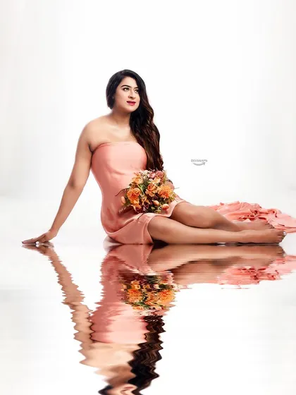 This elegant seated pose in a peach gown is enhanced by the clean white background and the beautiful water reflection I create in the studio, adding a touch of magic.