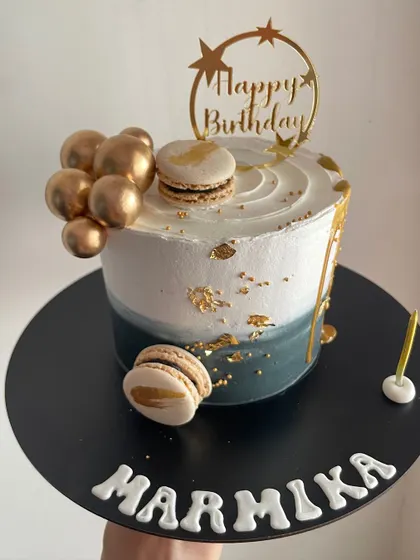 A chic and modern half-kilo cake with a blue-grey watercolor effect, gold leaf, and macarons.